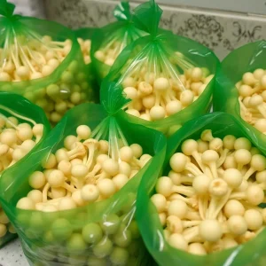 Enoki mushrooms in green plastic bags relating to a recall notice.
