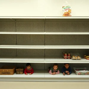 Empty food bank shelves highlighting the challenges faced by low-income families due to federal safety net cuts.