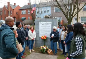 Community members gathered at the memorial site for restoration after vandalism.