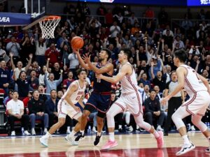 Hawks and Dukes players in a tense overtime basketball game